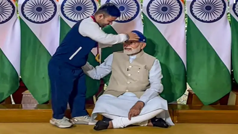 नवदीप सिंह के हाथों टोपी पहनने के लिए जमीन पर बैठ गये PM मोदी